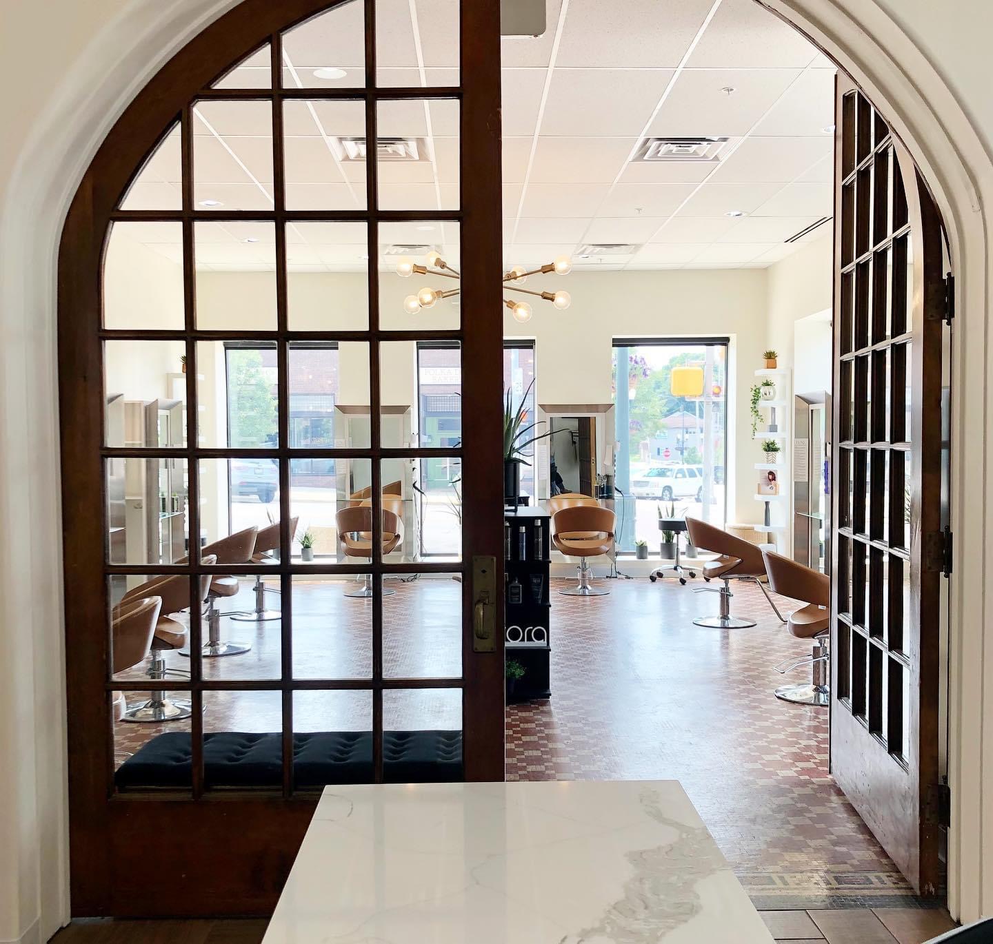Arched glass doors opening into a warmly lit salon